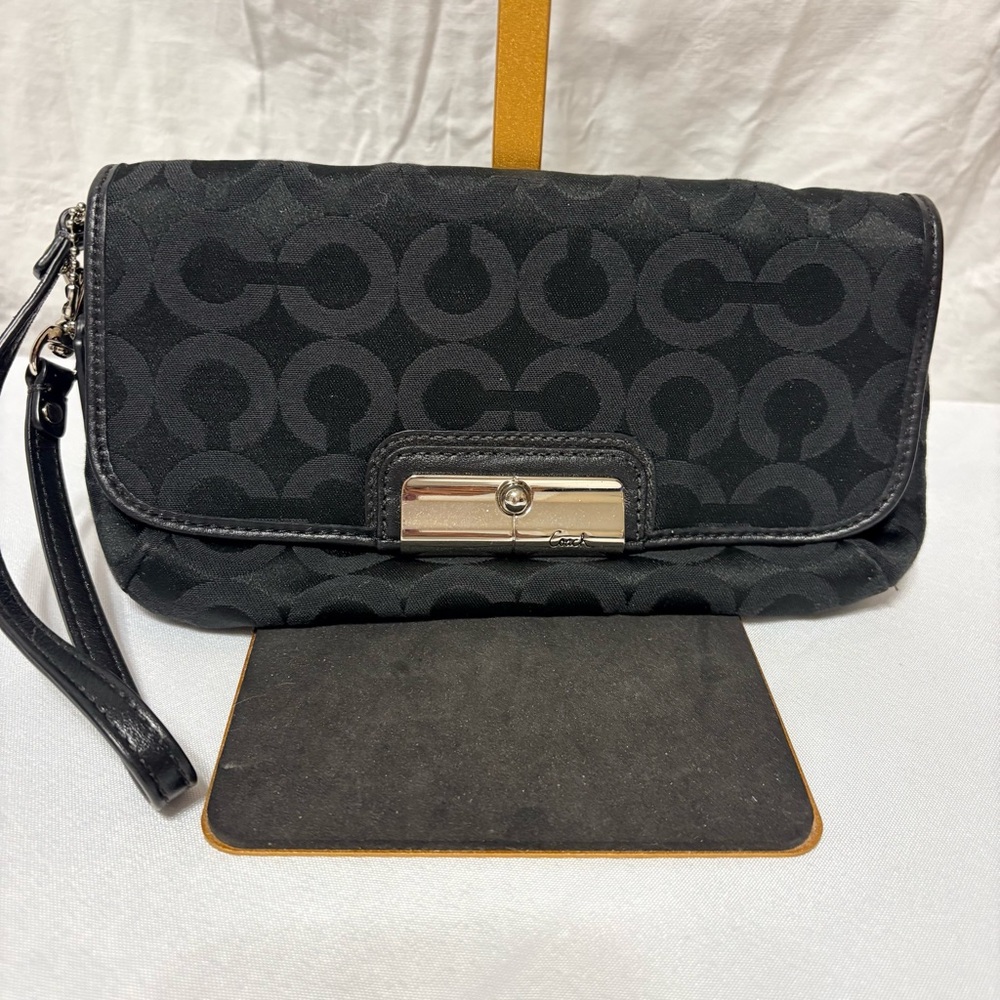 Black clutch wristlet, likely featuring silver-tone hardware - Picture 2 of 7